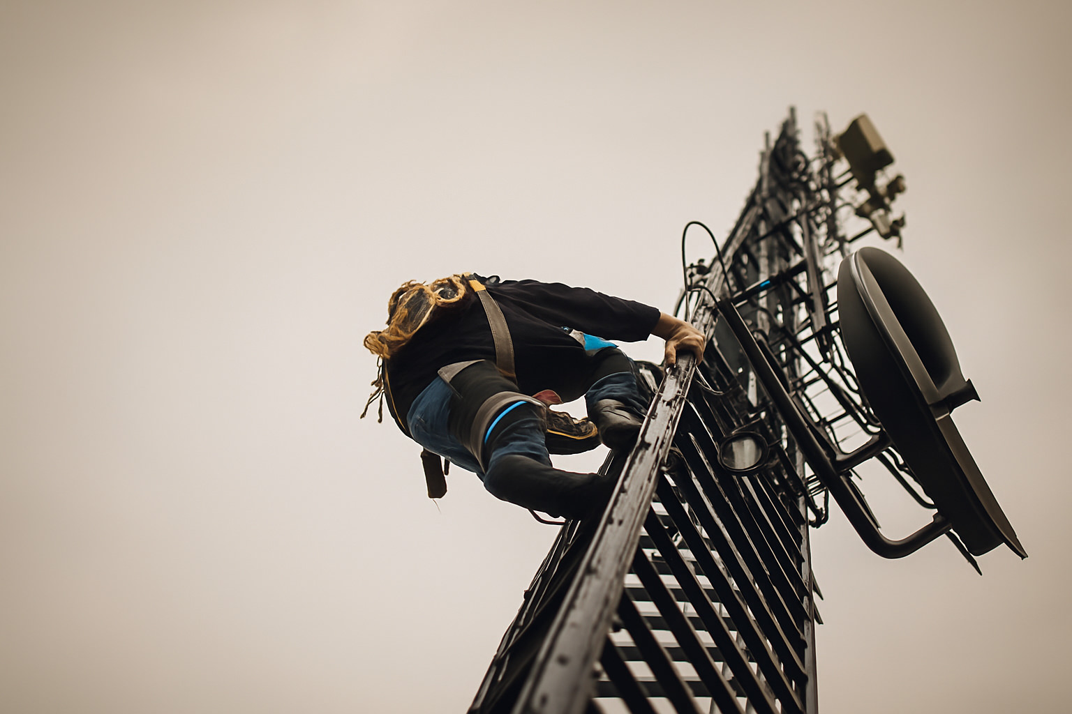 Un instalador de telecomunicaciones trepa por una torre de antena