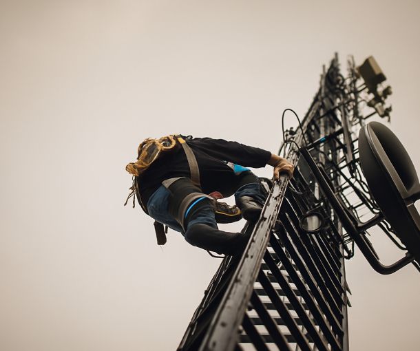 Un instalador de telecomunicaciones trepa por una torre de antena